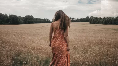 woman in orange dress on wheat field pretty in spanish slang