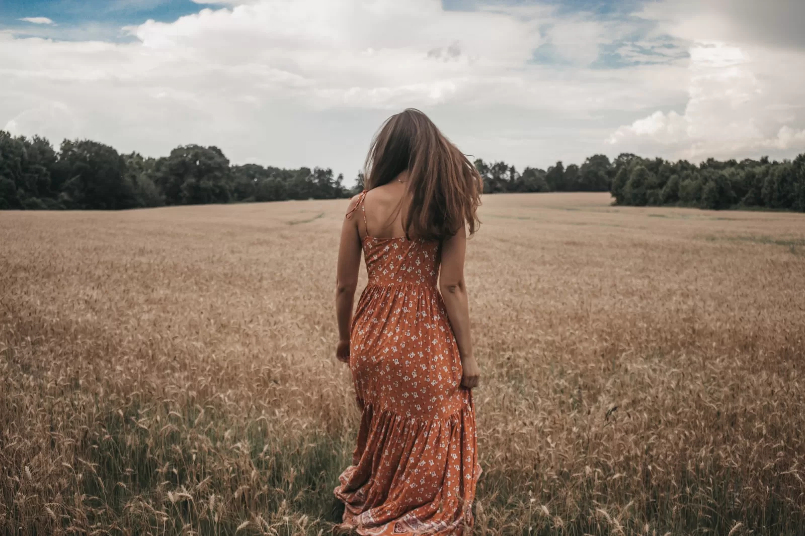 woman in orange dress on wheat field pretty in spanish slang