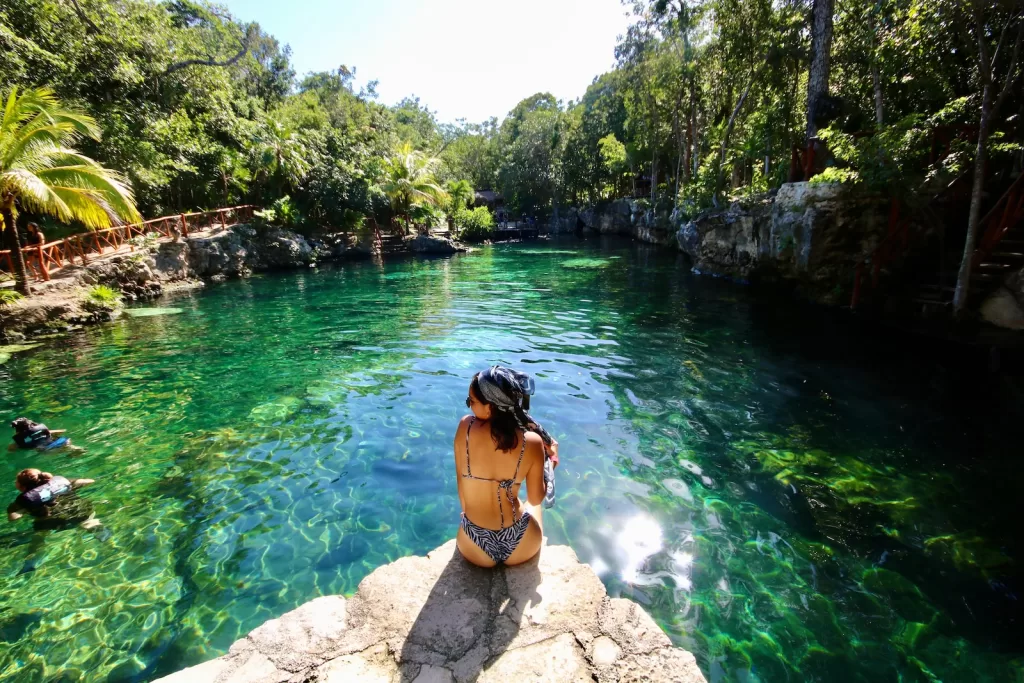 woman in black bikini standing on rock near river during daytime is the riviera maya safe