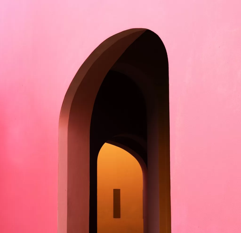 a pink wall with a doorway and a light at the end living in merida