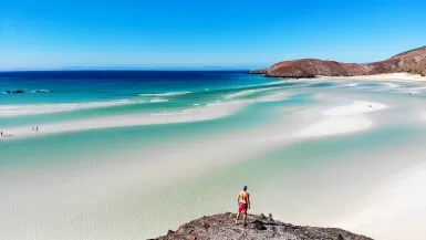 man standing on rock near sea