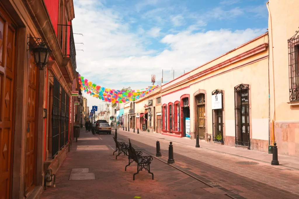 a street lined with benches and buildings under a blue sky Queretaro safest cities in mexico