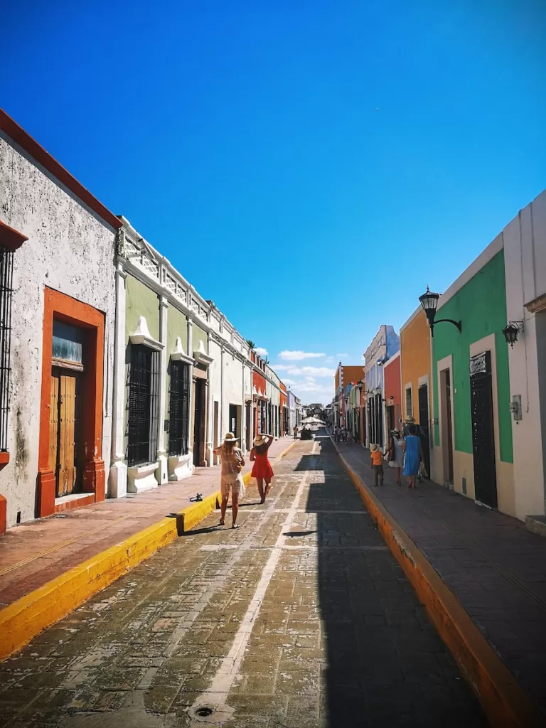 people walking on sidewalk near houses during daytime Puebla Mexico safest cities in mexico