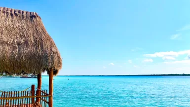 thatch hut above the sea during day bacalar mexico