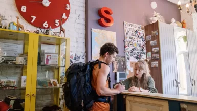 Tourist Standing in front of Reception Desk hostels in europe