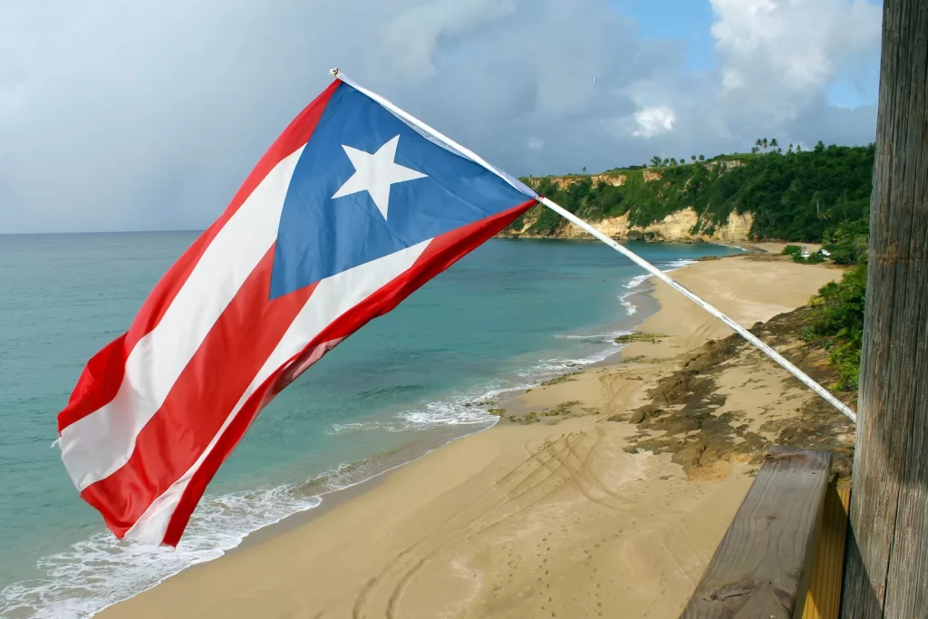 red and white flag on beach shore during daytime Puerto Rico fun facts
