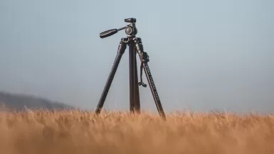 black camera and travel tripod on brown grass field during daytime