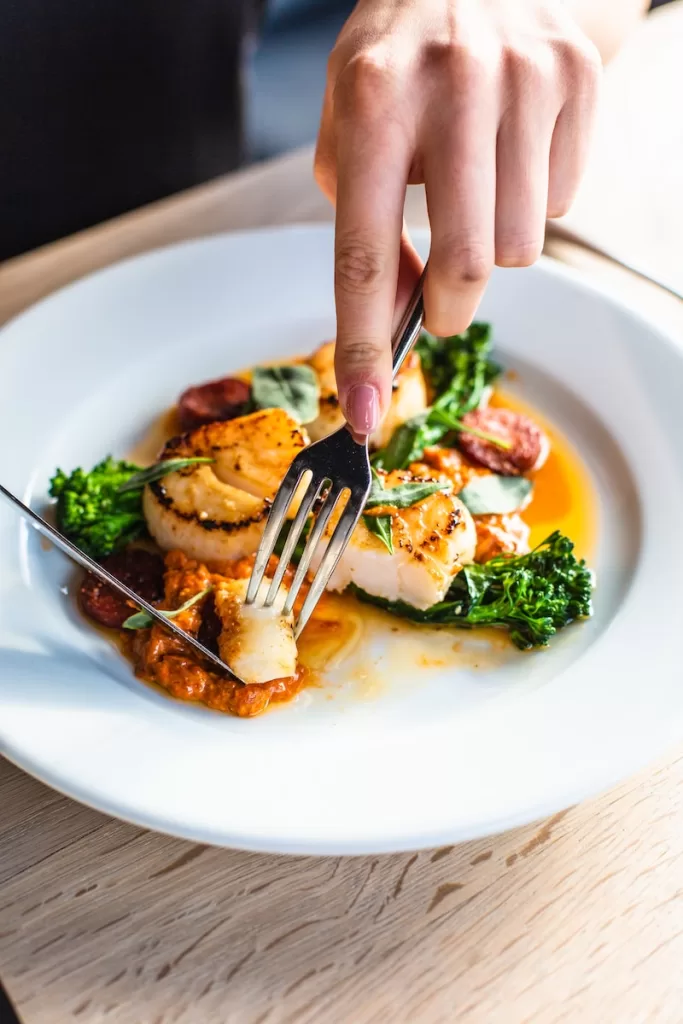 stainless steel fork on white ceramic plate Callo de Hacha in english