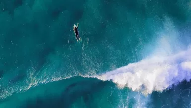 high-angle photography of man surfing giant wave Todos Santos, Baja California Sur