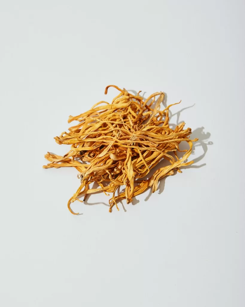 a pile of dried yellow flowers on a white surface Cordyceps: Energy and Stress Relief