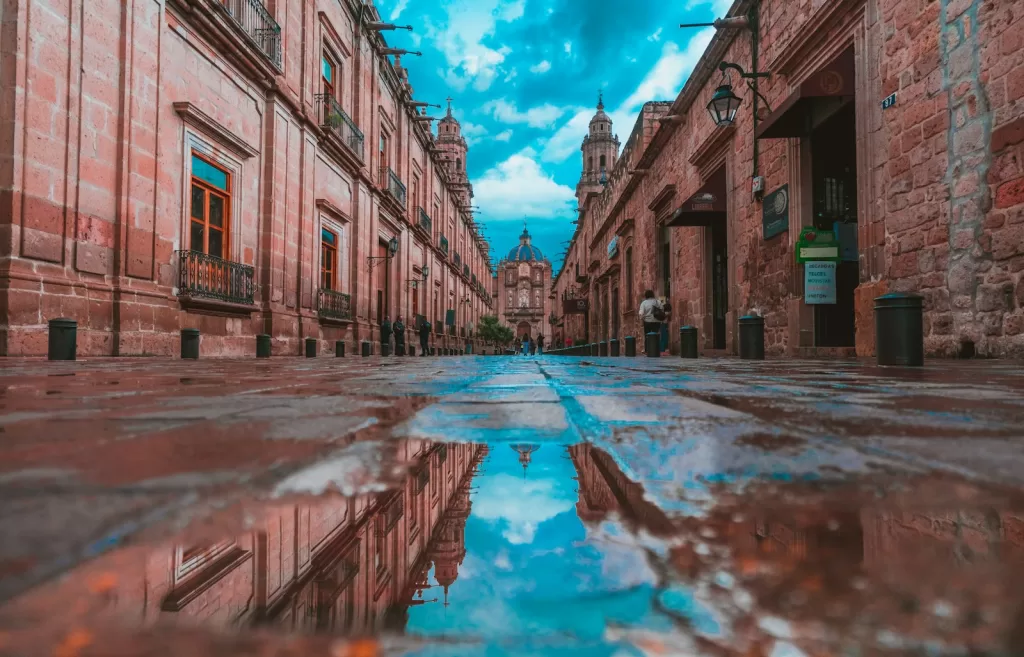 empty alley with buildings on side under blue sky in Morelia, Mexico