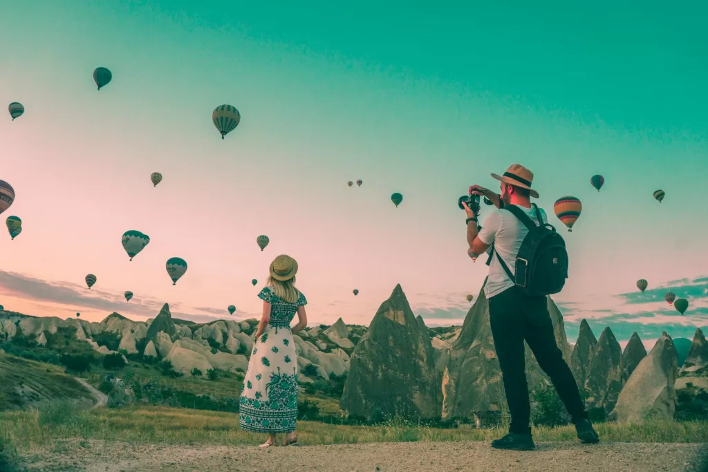 man taking photo of hot air balloons and Best Places to Travel in April