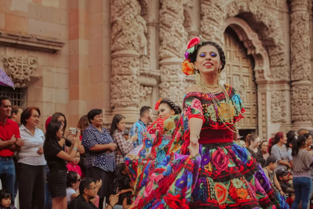 Mexico Festival with woman in a colorful dress dancing in front of a crowd 