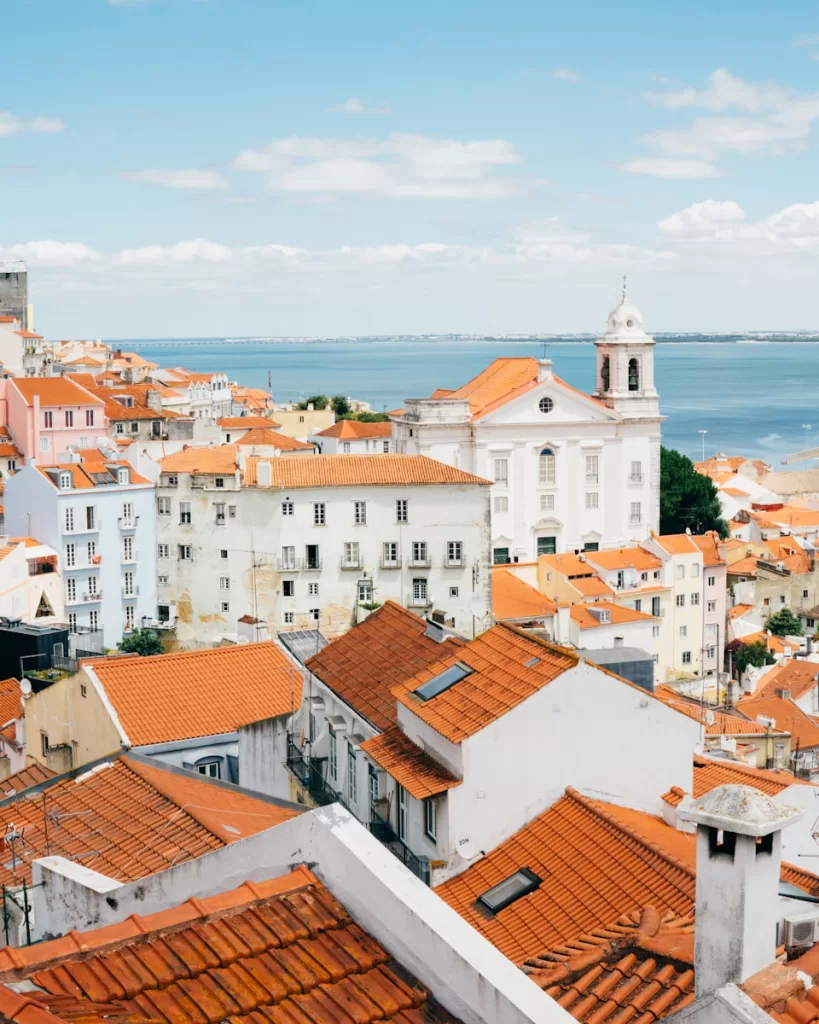 landscape photography of orange roof houses near body of water in Lisbon, Portugal and Best Places to Travel in September
