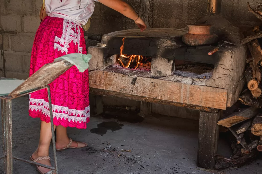 a person is cooking food in a wood stove in oaxaca