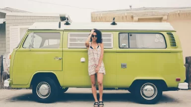 woman leaning on green bus in a Travel Dress