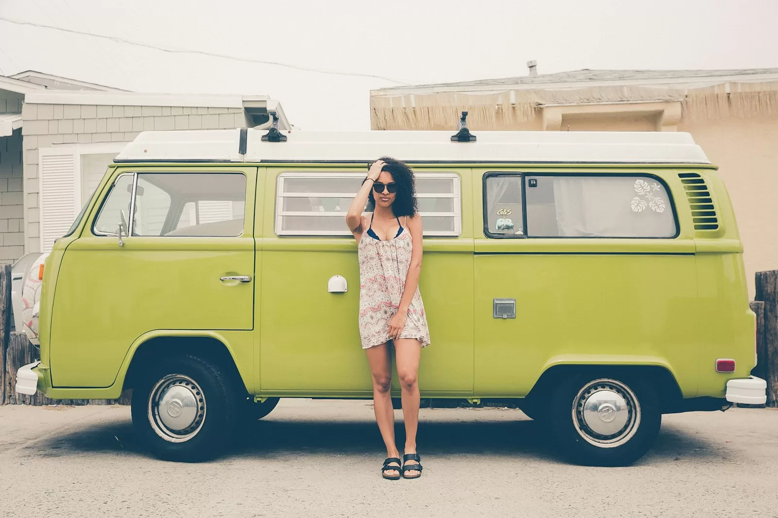 woman leaning on green bus in a Travel Dress