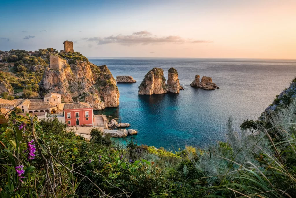 photo of house near cliff and body of water in Sicily, Italy