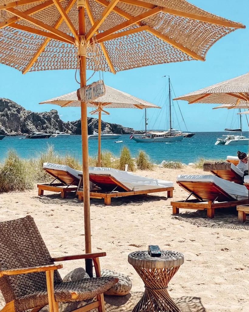 brown wooden beach lounge chairs on beach during daytime in ibiza and Best Places to Travel in September