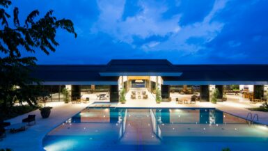 blue body of water in front of building near trees during nighttime hotel in guadalajara