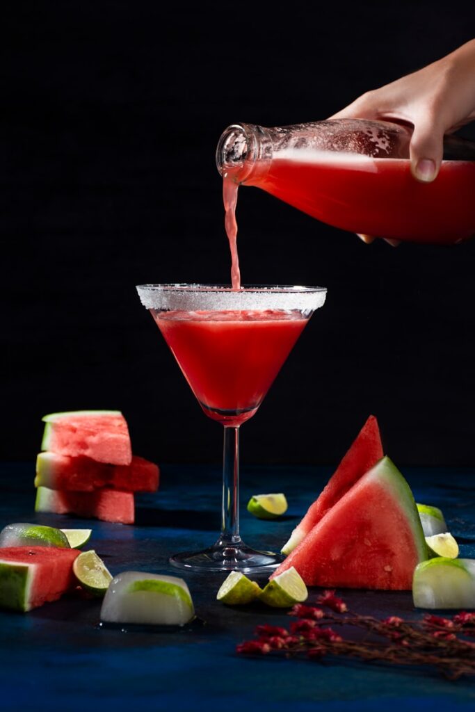 a person pouring a drink into a martini glass Watermelon Basil