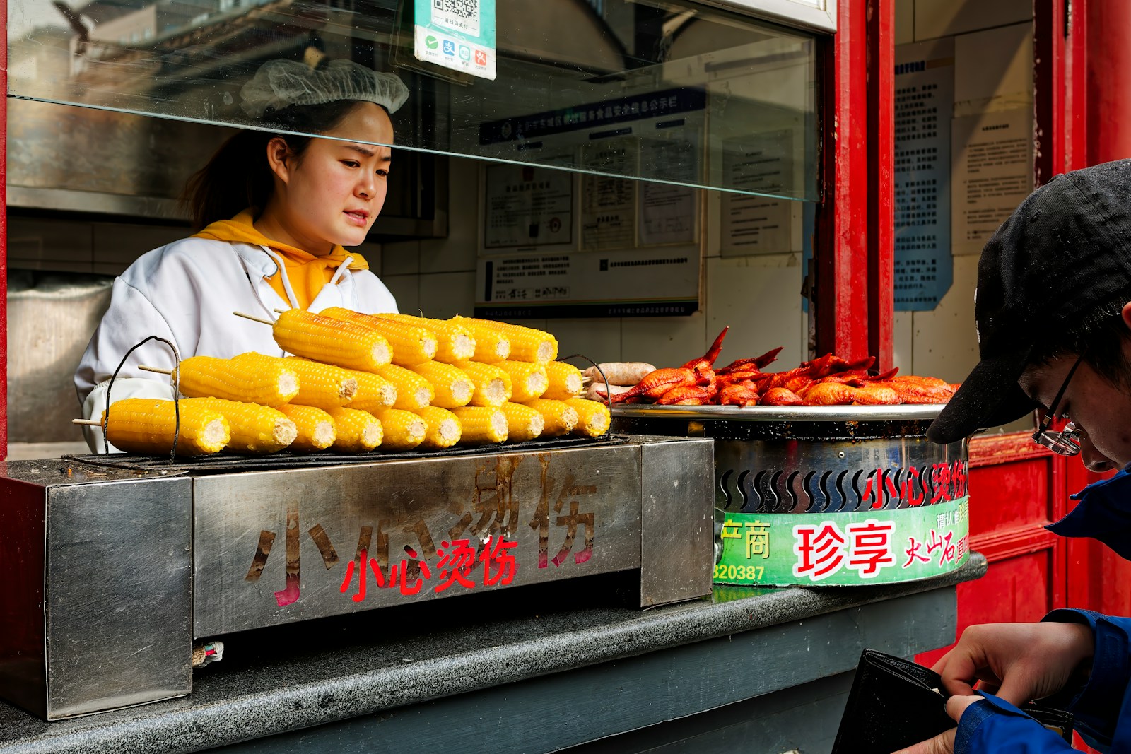 A woman standing in front of a food stand Local Cuisine