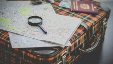 black magnifying glass on map Travel Plans