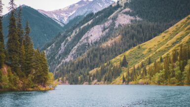 a body of water surrounded by mountains and trees Hidden Gem