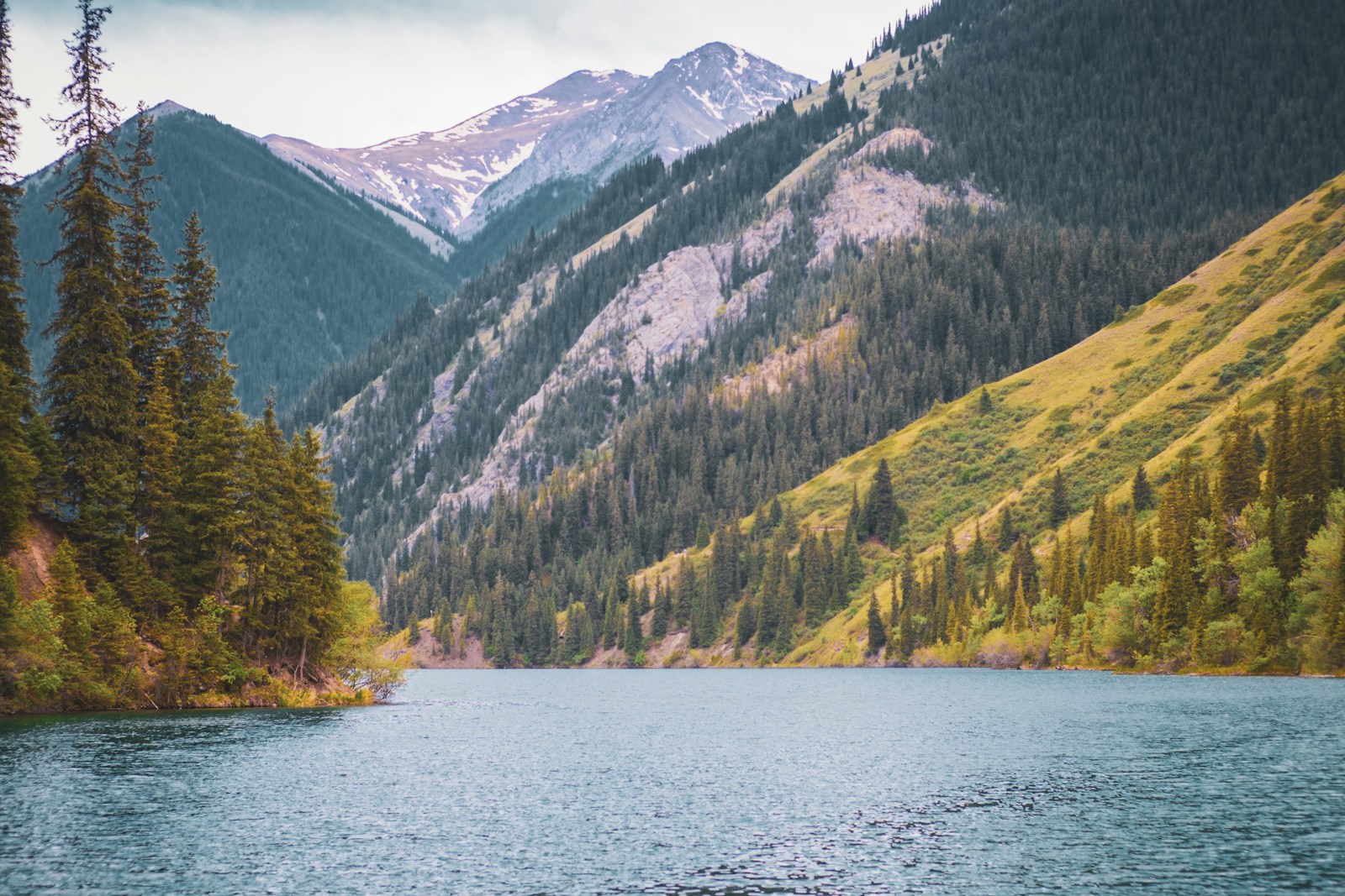 a body of water surrounded by mountains and trees Hidden Gem