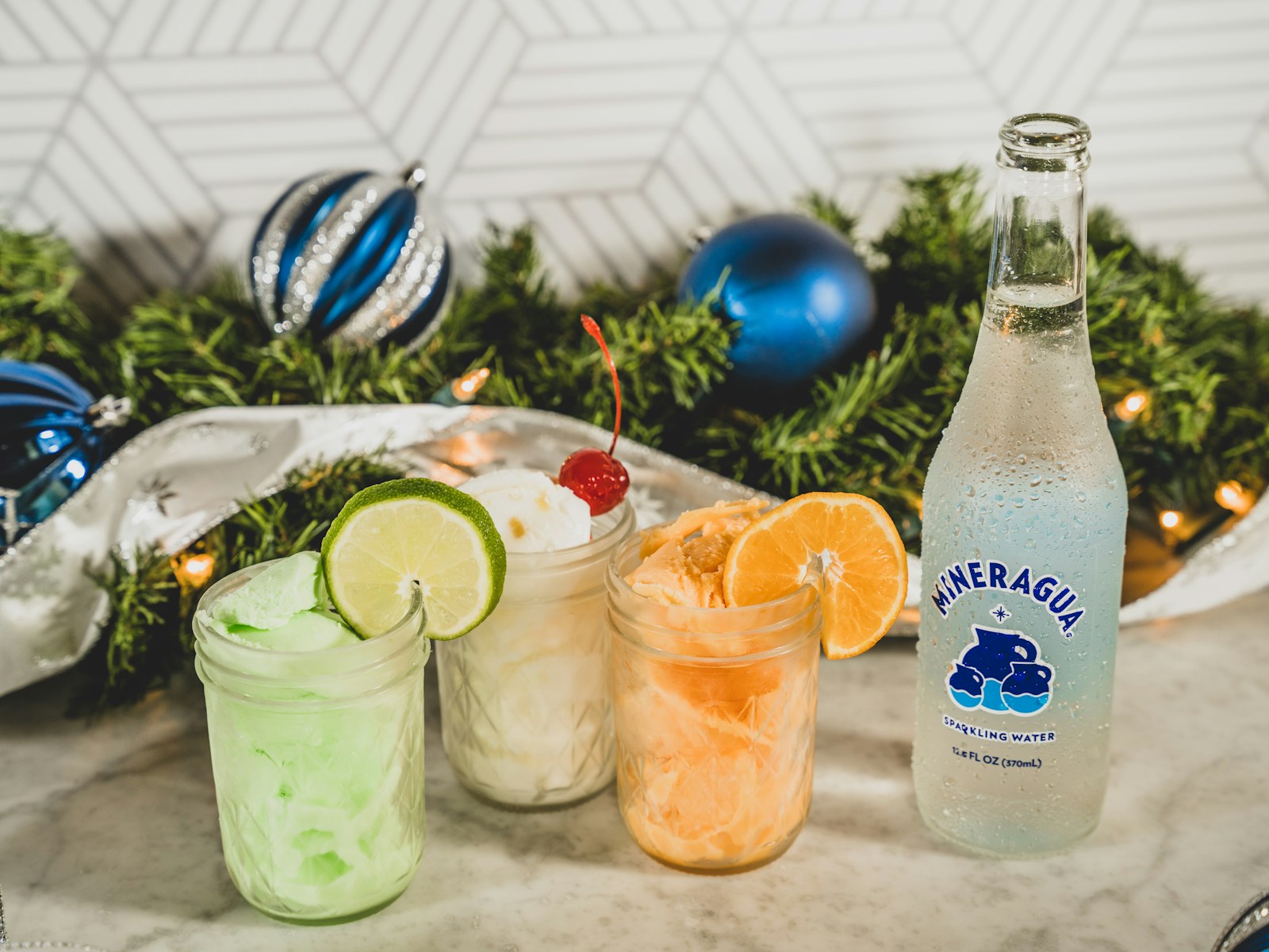 a bottle of lemonade next to three glasses of lemonade mocktail bar atlanta