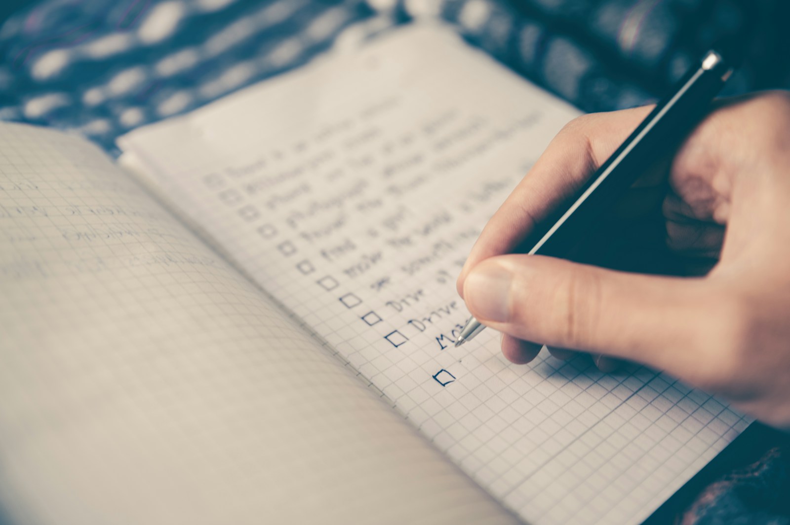 person writing bucket list on book Packing List