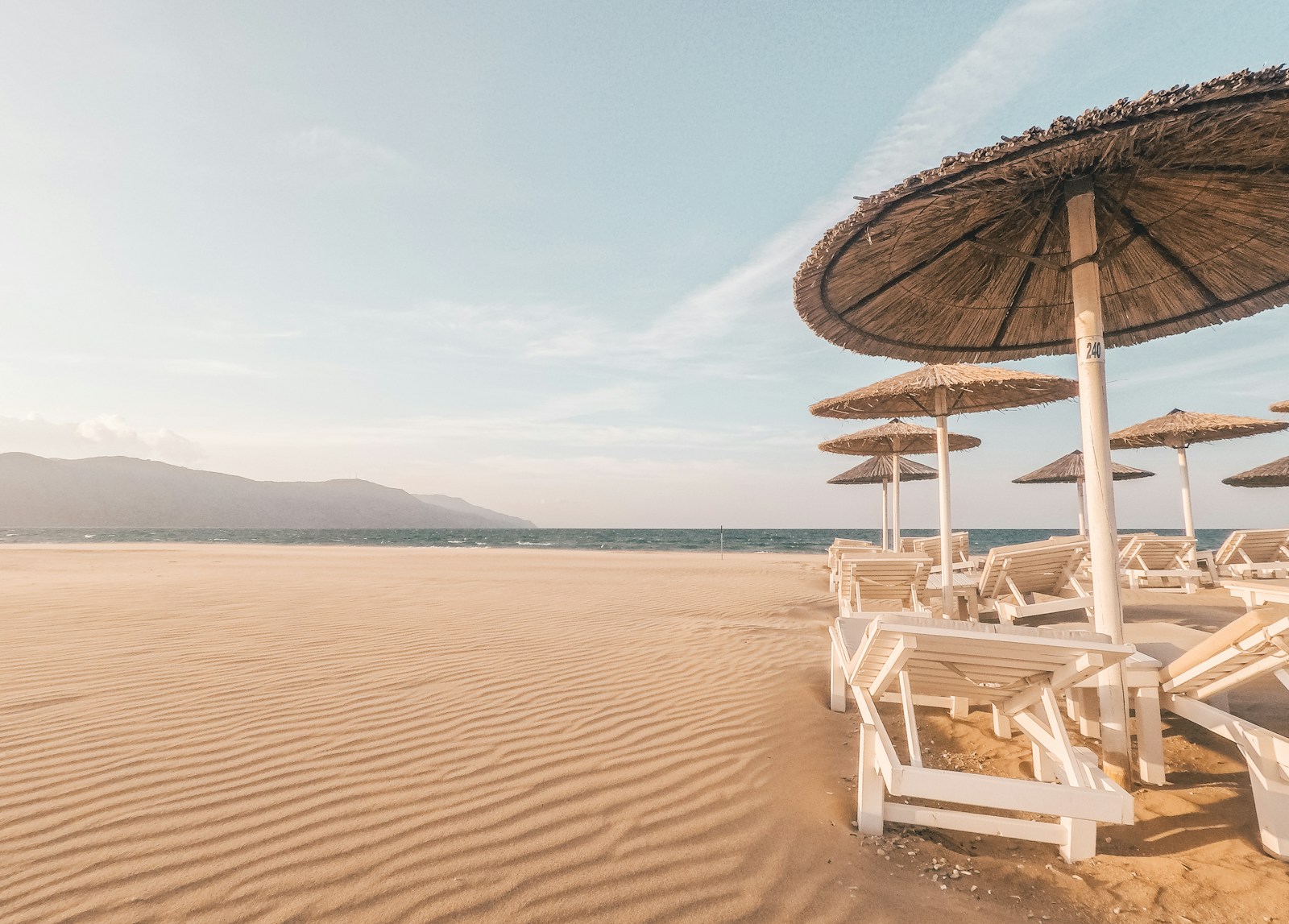 lounge chairs with umbrellas at the beach Weekend Getaway during day