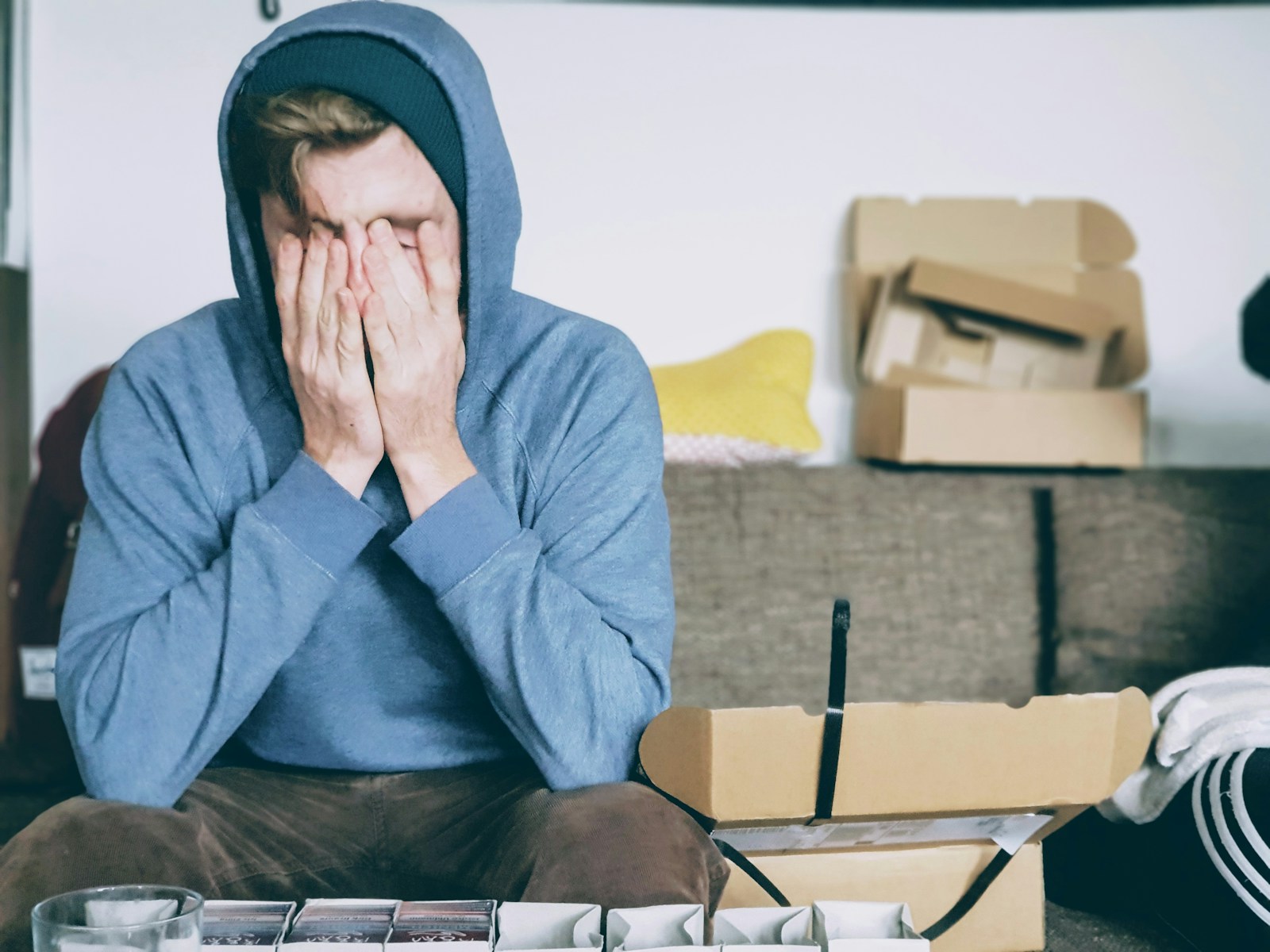 man covering face with both hands while sitting on bench Travel Anxiety