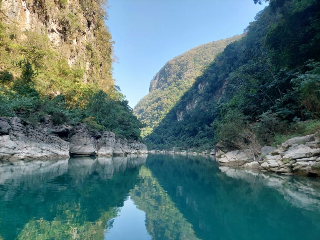 a body of water surrounded by mountains and trees Huasteca Canyon