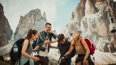 low-angle photography of two men playing beside two women travel friends