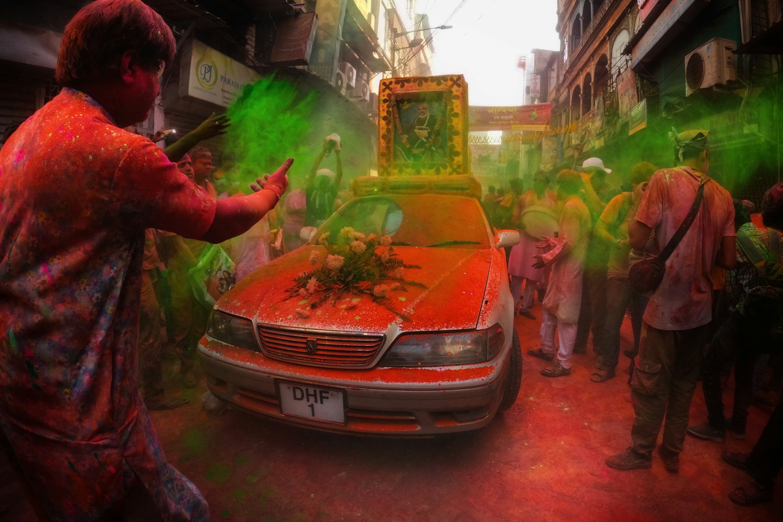 a group of people standing around a red car Cultural Traditions