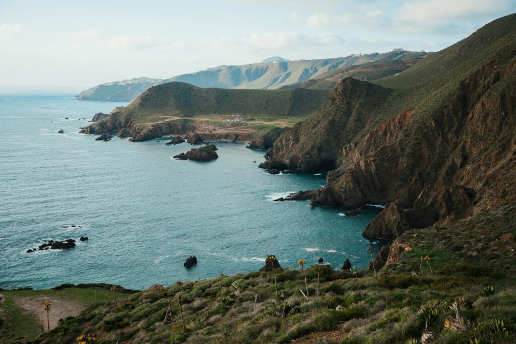 a body of water surrounded by mountains and greenery Ensenada beach