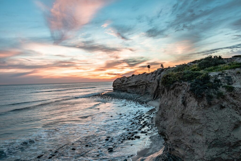 body of water beside mountain during daytime Living in Tijuana