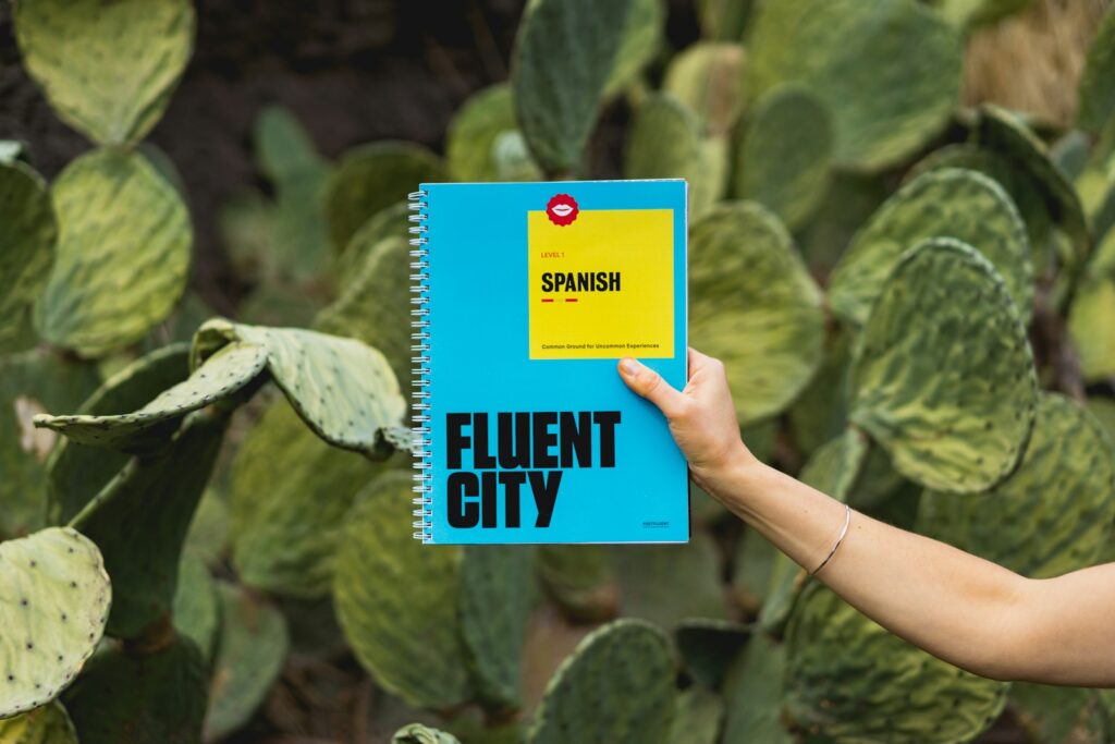 person holding Fluent City book small in spanish