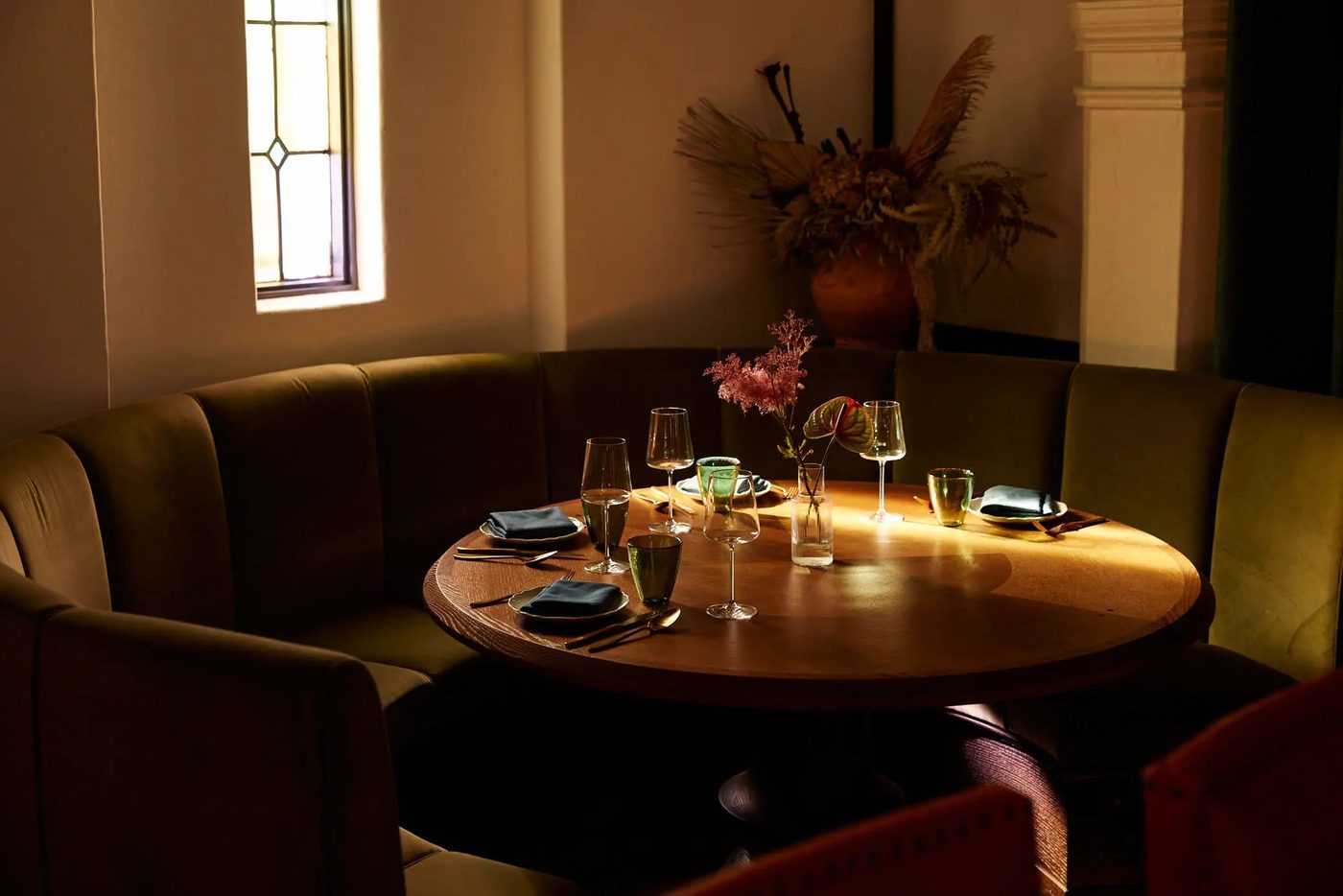 Curved banquette seating and warm evening ambiance inside Hotel Lucile