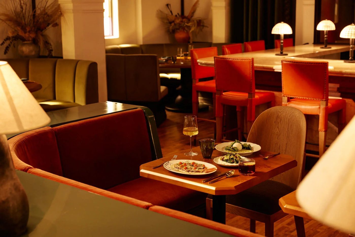 Sous Sous intimate dining tables with warm lamps and arched architecture